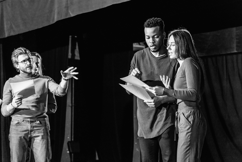 Actors reading over a script with a director giving some instructions