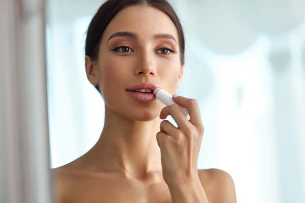 Lips Protection. Beautiful Woman With Beauty Face, Sexy Full Lips Applying Lip Balm, Lipcare Stick On. Portrait Of Female Model With Natural Makeup. Lips Skin Care Cosmetics Concept. High Resolution